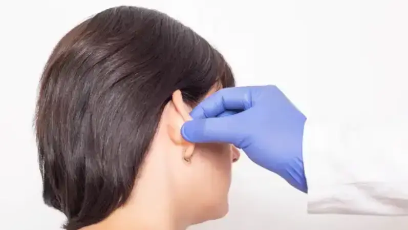 Doctor checking the ear lob of a woman